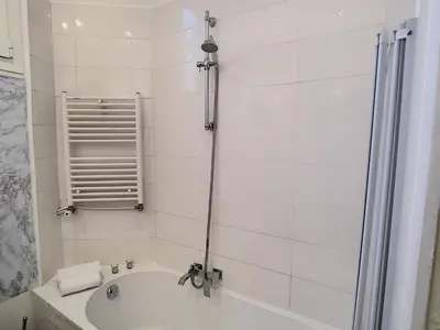 a white bathroom with a tub and a shower at Nestor&Jeeves - PALAZZO VERDI - Central in Nice