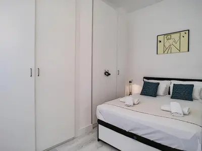 a white bedroom with a bed with blue pillows at Nestor&Jeeves - BEACH ROYAL - Central, Close sea in Nice
