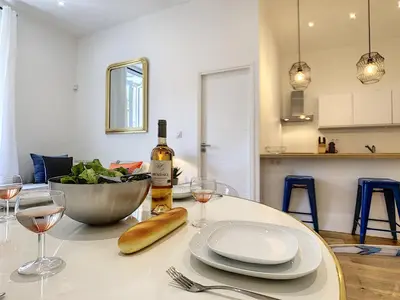 a table with a bottle of wine and two glasses at Nestor&Jeeves - COZY MACCARANI - City Center, Close sea in Nice
