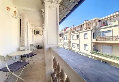 a balcony with a table and chairs on a building at Nestor&Jeeves - MADAGASCAR - 3 chambres, Centre-ville in Nice