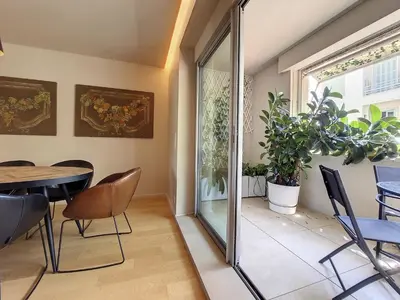 a dining room with a table and chairs and a window at Nestor&Jeeves - FLEURS TERRASSE - 3 chambres in Nice