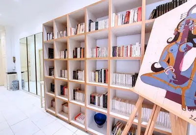 a library with wooden shelves filled with books at Nestor&Jeeves - FRENCHY - Hyper center, Closer sea and Place Massena in Nice