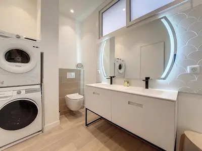 a bathroom with a washing machine and a washer and dryer at Nestor&Jeeves - MEDITERRANEE PROMENADE - Vue Mer in Nice