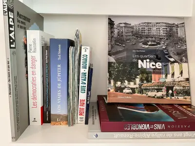 a shelf with books and magazines on it at La Prom 2 - a two bedroom apartment with a sea view in Nice