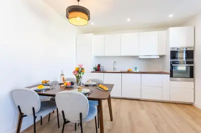 a kitchen with a wooden table and chairs in a kitchen at LE MONT ALBAN AP4360 By Riviera Holiday Homes in Villefranche-sur-Mer