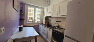 a kitchen with white cabinets and a sink and a window at Gloria apartments in Nice