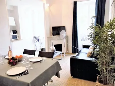 a living room with a table and a couch at Appartement confortable au cœur de Nice - Vue sur la ville in Nice