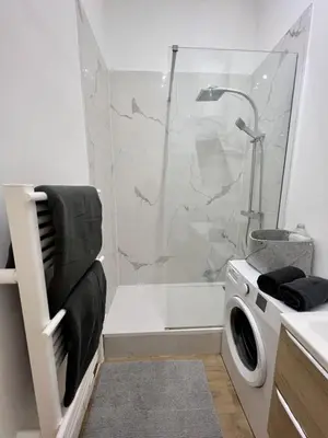 a bathroom with a shower and a washing machine at Sublime Appartement 2 pièces au cœur de la Vieille Ville in Nice