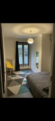 a bedroom with a bed and a yellow chair at Chez Nico in Nice