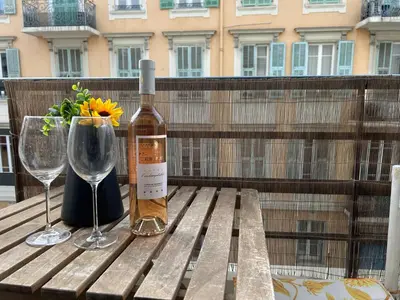 a bottle of wine sitting on a wooden table with a glass at Studio lumineux avec balcon à proximité de la mer in Nice