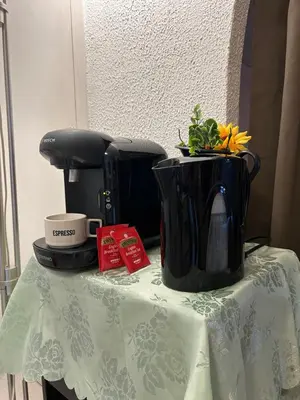 a table with a coffee pot and flowers on it at Studio lumineux avec balcon à proximité de la mer in Nice