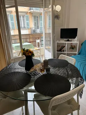 a dining room with a glass table with two chairs at Studio lumineux avec balcon à proximité de la mer in Nice