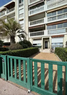 a green fence in front of a building at Riviera 1 ou Riviera 2 ou réservez les 2 Front de Mer Cagnes sur Mer Promenade de la plage in Cagnes-sur-Mer