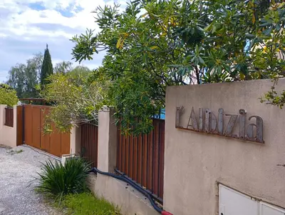 a sign on the side of a fence at L'Albizia in Nice