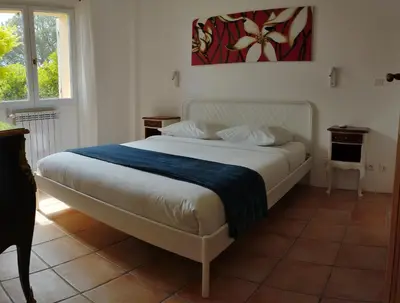 a bedroom with a white bed with a blue blanket at L'Albizia in Nice