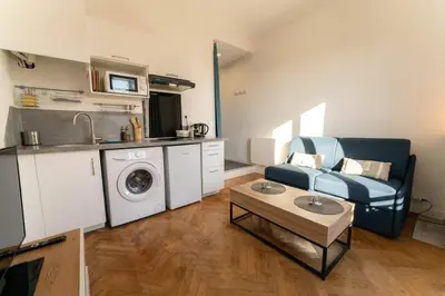 a living room with a couch and a washing machine at NICE CENTRE-VILLE STUDIO en étage in Nice