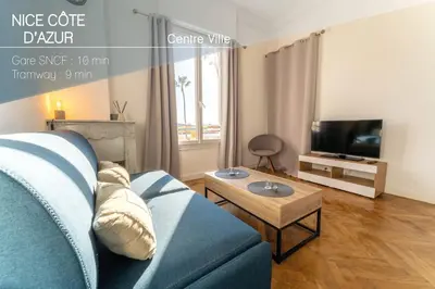 a living room with a blue couch and a tv at NICE CENTRE-VILLE STUDIO en étage in Nice