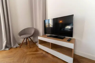 a living room with a television and a chair at NICE CENTRE-VILLE STUDIO en étage in Nice