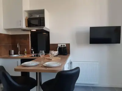 a kitchen with a table with chairs and a microwave at NICE Centre-ville Studio en étage refait à neuf in Nice