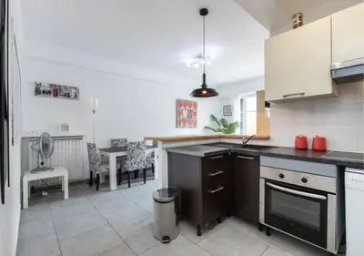 a white kitchen with a counter and stools in it at Beautiful & spacious 2 bed Apt near Nice Center in Nice