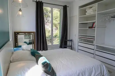 a bedroom with a large bed and a window at Les Lucioles - Vue mer, AC, Wi-Fi, 4 pers in Villefranche-sur-Mer
