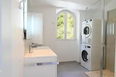 a white kitchen with a washing machine and a sink at Les Lucioles - Vue mer, AC, Wi-Fi, 4 pers in Villefranche-sur-Mer