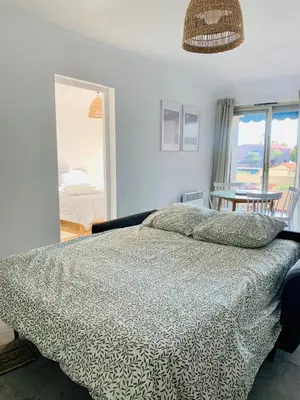 a bedroom with a bed and a view of a room at Cozy Beachside Apartment in Cros de Cagnes - Luna in Cagnes-sur-Mer