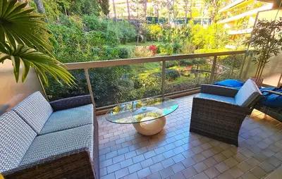 a balcony with two chairs and a glass table at Studio grande terrasse à 5 min de la mer in Nice