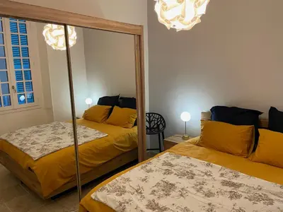 a bedroom with two beds and a mirror at Vieux-Nice 3 pièces confortable et calme in Nice