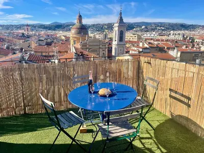 a table with a bottle of wine on top of a city at Triplex Toit-Terrasse Authentique Vieux-Nice & Mer in Nice
