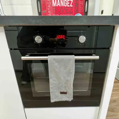 a oven with a towel on the door of it at Beautiful Top Floor & Terrasse (Beach 1' walk) in Nice