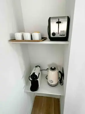a kitchen shelf with a toaster and appliances on it at Beautiful Top Floor & Terrasse (Beach 1' walk) in Nice