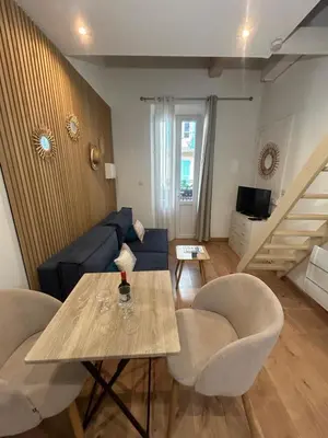 a living room with a table and a couch at Le ruisseau in Nice