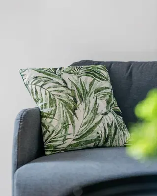 a green and white pillow on a couch at Studio Nicehome Massena in Nice