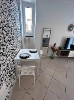 a white table and chairs in a living room at Studio dans villa proche mer in Nice