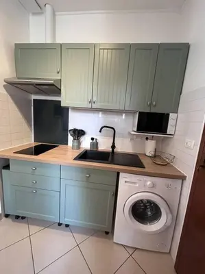 a kitchen with a sink and a washing machine at Studio dans villa proche mer in Nice