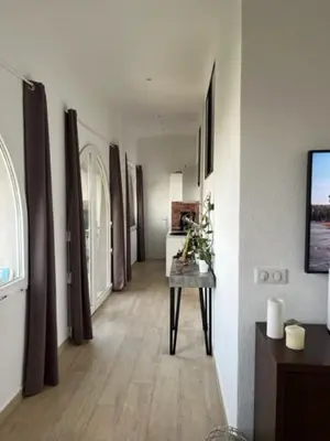 a room with a hallway with a table in it at Superbe appartement grande corniche vue sur mer Nice à 4 min du centre ville in Nice