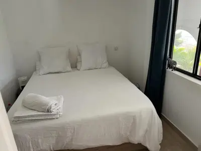 a white bed in a room with a window at Superbe appartement grande corniche vue sur mer Nice à 4 min du centre ville in Nice