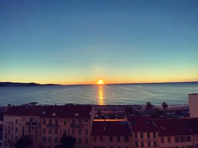 a sunset over the ocean in a city at Magnifique vue mer la Californie in Nice