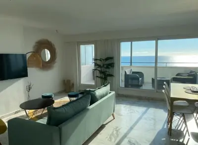 a living room with a couch and a table at Magnifique vue mer la Californie in Nice