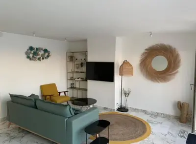 a living room with a blue couch and a tv at Magnifique vue mer la Californie in Nice