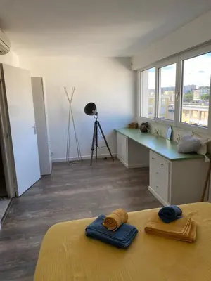 a bedroom with a bed and a desk with towels at Magnifique vue mer la Californie in Nice