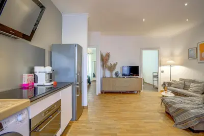 a living room with a kitchen and a couch at Maison Bianchi - Chauvain Place Massena in Nice