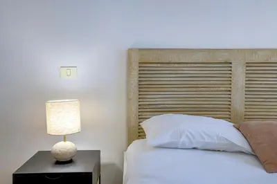 a bedroom with a bed and a lamp on a night stand at Maison Bianchi - Chauvain Place Massena in Nice