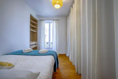 a white bedroom with a bed and a window at Maison Bianchi - Chauvain Place Massena in Nice