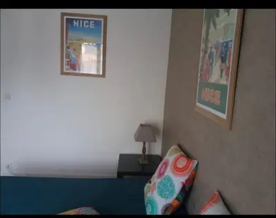 a living room with a blue couch and a wall at En plein coeur de Nice in Nice