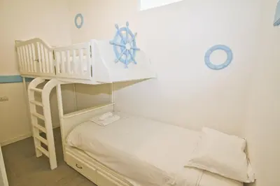 a small bedroom with a bunk bed with a ladder at Garden Floor Condo with Promenade Sea View in Nice