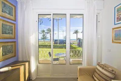 a living room with a door with a view of the ocean at Garden Floor Condo with Promenade Sea View in Nice
