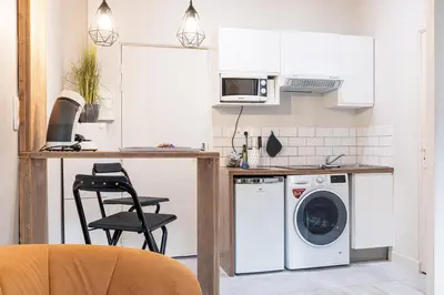a kitchen with a washing machine and a chair at Le PETIT JEAN- CENTRAL PRES GARE ET TRAM - supermarchés - WIFI - in Nice