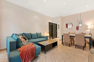 a living room with a blue couch and a dining room at Nice - Renting - LASCARIS - Charm & Spacious & Comfort 3P Port Bonaparte in Nice